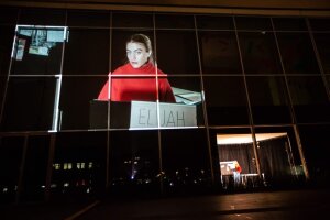 La lecture est filmée depuis une micro-scène et projeté sur la façade du lieu.